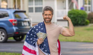 Amerikan bayrağı ve dolar parası olan adam. Enflasyon konsepti. Amerikan vergi politikası. İspanyol adam ve Amerikan bayrağı. Amerika 'da vergi ödemek. Katma değer vergisi. Vergi sistemi. Vatansever güçlü adam.