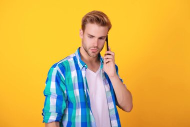 Millennial Man 'in telefon görüşmesi var. Geri arıyorum. Adam akıllı telefonda konuşuyor. Telefon var. Mobil iletişim. İletişim. Akıllı telefondan konuşan adam sarıda izole edilmiş. Merhaba..