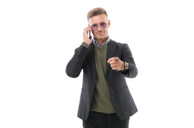 Adam akıllı telefonda konuşuyor. Telefon var. Mobil iletişim. İletişim. İş adamı, beyaz telefondan izole edilmiş bir şekilde konuşur. İş adamı telefon görüşmesi yapar. İş görüşmesi. İşaret parmağı.