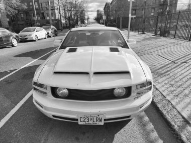 New York City, ABD - 18 Mart 2024: Ford Mustang GT coupe sarı spor araba, ön manzara.