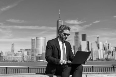 Başarılı bir iş adamı Manhattan, New York 'ta bilgisayarla online iş yapıyor..