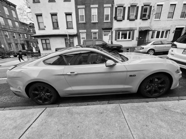 New York, ABD - 10 Mart 2024: 2018 Ford Mustang sarı spor arabası, yan görüş.