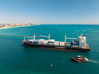 Miami, Florida, ABD - 20 Mart 2025: Miami deniz limanı. Monrovia konteynırı gemisi. Kargo Seaboard Explorer konteynır gemisi, hava manzaralı. Yük konteynırı kargo gemisi ve römorkör. Kargo gemisi.