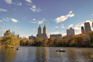 New York City, ABD - 11 Kasım 2023 Central Park New York 'taki insanlar sonbahar ağaçlı Central Park. Sonbahar doğası. New York City Central Park 'ta gölde teknesi var. Sonbahar manzarası.