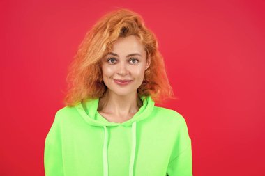 Moda kıyafetleri ve tarzı. Kazaklı beyaz bir kadın. Sıradan bir yaşam tarzı. Havalı kapüşonlu giyen kızıl saçlı kız. Pembe üzerine izole edilmiş şık bir kadın. Hareketli moda kız kapüşonlu giyer. Boşluğu kopyala.