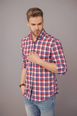 Gri tişörtlü adam izole edilmiş. Saç stili olan yakışıklı bir genç. Moda erkek modası. Normal erkek stili. Cilt bakımı ve erkeklerin güzellik anlayışı. Kafkasyalı milenyum adamı. Stüdyoda poz veren adam.