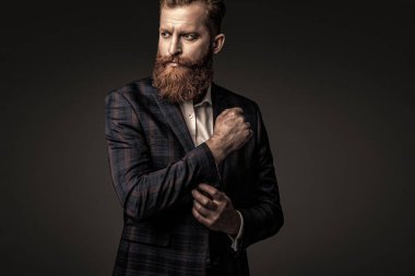 Özel dikim erkek giysisi giymiş sakallı adam. Özel dikim kıyafet giyen bir iş adamı. Şık takım elbiseli bir iş adamı. Resmi terzilik kıyafeti. Erkek giyim kuşamı. Bespoke takımı..