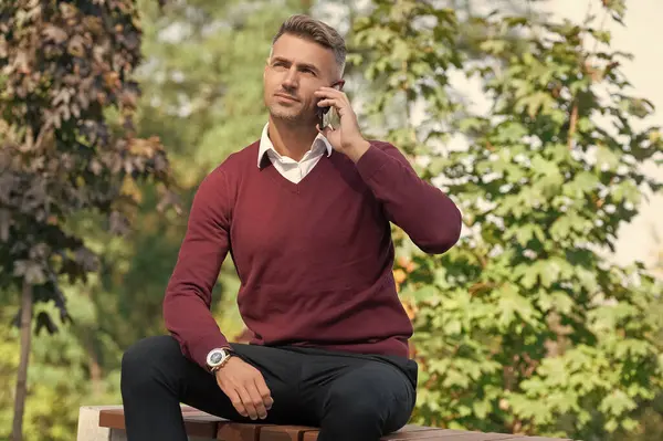 Olgun adam çağırıyor. Adam telefonda konuşuyor. Telefon var. Mobil bağlantı. Akıllı telefonlu bir iş adamı. İş iletişimi. Modern iletişim. Adam dışarıda telefonla konuşuyor. İş adamını arıyorum..