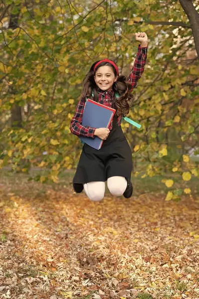 Kızların okul eğitimi. Bilgi ve eğitim. Sonbahar indirimi. Bilgi toplama günü. Sonbahar okulu ödevinde atlayan kız. Okula dönelim. Ödevi olan genç kız sonbahar parkında zıplıyor. Nihayet tatil..