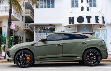 Miami, Florida, ABD - 08 Aralık 2024: Luxur yeşil renkli Lamborghini Urus S tipi spor araba. Lamborghini Urus 'un arabası dışarıda park halinde. Lamborghini Urus, yan görüş. 2024 Lamborghini Urus S SUV arabası.