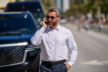 Telefon kullanan bir iş adamı. İş görüşmesi. Erkek telefon konuşması. Telefonu olan olgun bir İspanyol iş adamı. İş geliştirme. Müzakere çevrimiçi. İş adamı dışarıda telefonla konuşuyor..