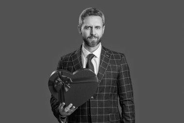 İş adamı sevgililer gününe hazırlanıyor. İş ödülü. Şirketin hediye kutusuna sahip iş adamı Grey 'de izole edilmiş. Kurumsal ödül. Erkekler günü. Başarılı patron hediye kutusunu paylaşıyor. Gizli Sevgililer.