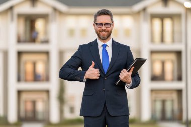 Başarılı bir komisyoncu. İpotek sigortacısı. Amerikalı satış müdürü. Satılık bir emlakçı. Takım elbiseli bir emlakçı. Kirala ya da yeni bir ev al. Ev sigortası. Emlak sigortası tanıtımı. Başparmak yukarı..