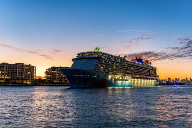 Miami, Florida, ABD - 24 Aralık 2024: Gemi gece aydınlandı. Norveç 'ten ayrılan yolcu gemisi yolculuğu. Yaz tatilinde gemi turu. Norveç yolcu gemisi. Gemi turu ve okyanus seyahati.