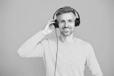 Beyaz adam mavinin üzerinde izole edilmiş. Olgun adam sesi dinle. Olgun bir adam kulaklıkla müzik dinler. Müzik konsepti. Modern mutlu yaşam tarzı. Müzik kulaklıklarıyla ses dinleyen adam. & Çalış.