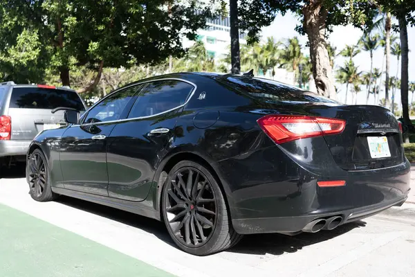 Miami, Florida, ABD - 17 Aralık 2024: Black 2014 Maserati Ghibli spor yara izi. Maserati Ghibli 'nin lüks spor arabası. Maserati Ghibli 'nin arabası dışarıda park edilmiş. Siyah Maserati Ghibli, köşe görünümü.