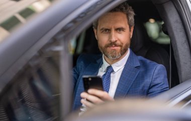 Takım elbiseli bir adam arabada telefon kullanıyor. Telefonu olan İspanyol bir işadamı. Başarılı bir bayilik. İş adamının telefonu var. Araba sigortası. Başarılı bir araba satıcısı. Satış. Lüks araba yolculuğu..