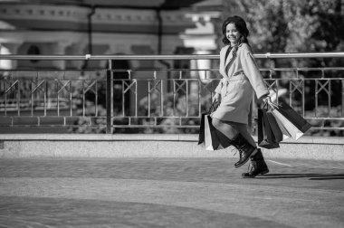 Genç kız açık hava alışverişi yapıyor. Alışverişçi kız için sonbahar modası. Sonbahar alışverişi. Sonbahar moda kızı için kıyafetler. Genç kız gardırobu yeniledi. Sonbahar indirimi ve indirim. kopyalama alanı. Kelepir avcı.