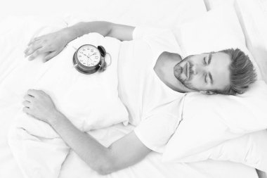 Sabah uyanması. Yatakta yatarken çalar saati olan uykucu adam. Sabah uyanışı. Uykulu adam çalar saati kapatıyor. Erken kalkmak. Uyanma ve kalkma vakti geldi. Tembel Pazar.