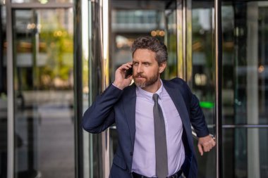 Patrona telefon var. İletişim ve müzakere. İş adamı dışarıda telefonla konuşuyor. İş adamının telefonu var. Ofiste iş görüşmesi. İş görüşmesi çağrısı. Şirket işi..