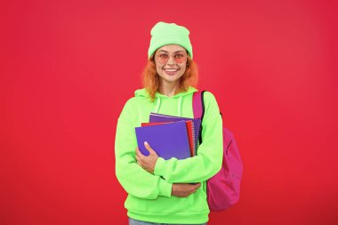 Üniversitede ya da üniversitede ev ödevi yapan genç bir kız öğrenci pembe üzerine izole edilmiş..