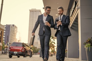 Başarı. Takım elbiseli işadamları dışarıda yürüyor. Şehirde yürüyen ve konuşan iki işadamı. İş adamları konuşuyor. Yürüyen ve konuşan iki iş adamı. New York 'ta iş arkadaşı yürüyüşü.
