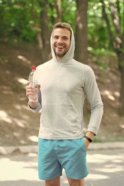 Susadım. Plastik şişeli genç bir adam. Sağlıklı bir yaşam tarzı. Vücutta su elektrolit dengesi. Günde bir içki. Sıvı yeterliliği. Susuz kalma. Susamış sporcu. Adam maden suyu tutuyor..