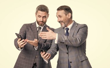 İş mesajlaşması. İnternet üzerinden iş mesajlaşması. Takım elbiseli iş adamları telefon kullanır. Mesajlaşan iki işadamı e-postaları kontrol ediyor. Telefondaki mesajları okuyan iş adamları beyazdan izole edilmiş. Metin platformu.