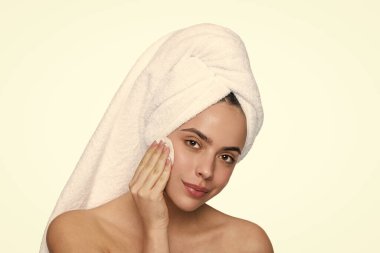 Cilt bakımı. Makyajı sil. Güzellik rutini. Havluyla yüz temizleyen kadın derisi. Pamuk yumağıyla deriyi temizliyor. Cilt kozmetolojisi. Kaplıcada güzellik günü. Kadın pamuk pedi kullanıyor. Küçültücü.