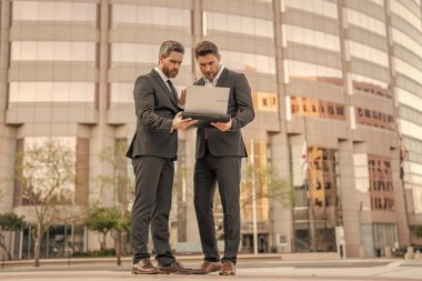 Dizüstü bilgisayarda çalışan adamlar. Çevrimiçi çalışan iş adamları. Dizüstü bilgisayarlı iş adamları. Çalışıyorum. İş adamları e-postaları kontrol ediyor. İş adamları dışarıda serbest çalışıyor. İnternette iş. New York.