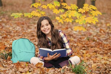 Sonbahar kitabı. Okula dönelim. Okul eğitimi. Dışarıda kitap okuyan liseli kız. Genç kız sonbahar parkında kitap okuyor. Eğitim ve bilgi. Bilgi toplama günü. Kendi kendine eğitim. Zeki üniversite öğrencisi..