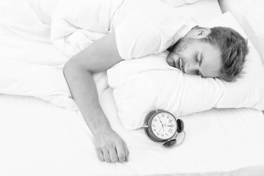 Erken kalkmak. Uyanma ve kalkma vakti geldi. Sabah uyanması. Yatakta yatarken çalar saati olan uykucu adam. Sabah uyanışı. Uykulu adam çalar saati kapatıyor. Uyku rejimi.