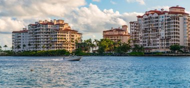 Marinaya yüzen bir tekne. Fisher Adası 'nda lüks bir yat teknesi. Yaz tatili. Fisher Adası konut binası ve lüks yat teknesi. Miami 'de Fisher Adası' na yat gezisi..