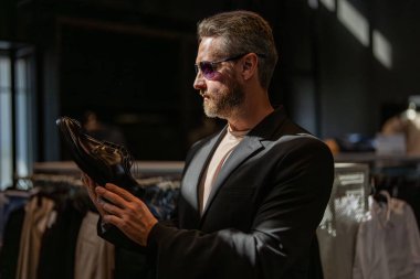 Klasik deri ayakkabı resmi görünümü. Resmi ayakkabı. Deri ayakkabılar. Ayakkabı mağazasındaki tezgahtar adam klasik ayakkabıları tutuyor. Ayakkabı mağazası. İş adamı dükkanda şık ayakkabılar seçer. Müşteri hizmetleri.
