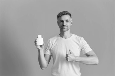 Multivitamin ve vitamin. Günlük takviye. İlaç teklif et. Acıyı dindirmek için ilaç. İnsan maviden yiyecek desteğini ayırır. Haplı ya da vitaminli bir adam. Enerji ilacını sunuyorum. Başparmak yukarı..