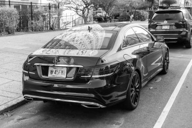 New York City, ABD - 15 Mart 2024: 2014 Mercedes Benz E550 lüks araba dışarı park, arka manzara.