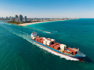 Denize bakan kargo gemisi. Kargo işi. Konteyner gemisi. Nakliye lojistiği. Ticari nakliye. Kargo gemisi denizde, hava manzaralı. Yük konteynırı kargo gemisine yüklendi.