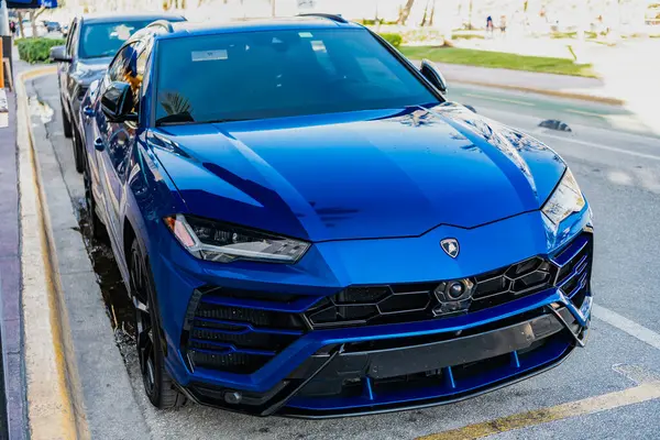 Miami, Florida, ABD - 23 Kasım 2024: Mavi Lamborghini Urus 2020 SUV spor yara izi. Lamborghini Urus tipi lüks bir spor araba. Lamborghini Urus dışarıda park etmiş. Lamborghini Urus, alçak köşe manzaralı..