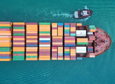 Kargo gemisinde nakliye konteynırı. Kargo gemisi limandan ayrılıyor. Konteyner gemisi. İhraç ve ithalat. Kargo işi. Nakliye lojistiği. Konteynırlı kargo gemisi, hava manzaralı. Denizden İçeriye Aktar.