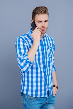 Cep telefonuyla konuşan bir adam. Telefon var. Mobil bağlantı. Kulaklıklı adam. Öğrenci yaşam tarzı. Modern iletişim. Grey 'de izole edilmiş bir adam telefonda konuşuyor. Millennial Man 'e telefon var. İş çağrısı.