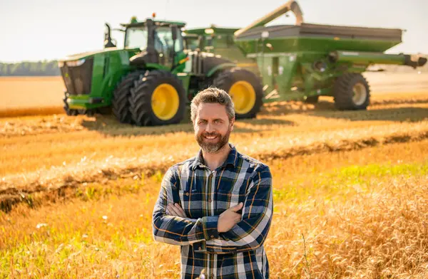 Kırsal kesim. Agronomist adam mahsul tarlası hasat ediyor. Olgun tarım. Sahadaki hasatçıyı. Çiftçi tarım uzmanı. Ekin hasadı. Çiftçi buğdayı kontrol ediyor. Hasat zamanı tarım buğdayı. Sürdürülebilirlik.