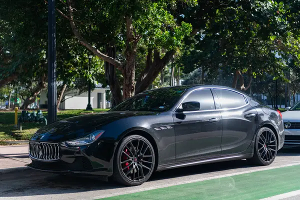 Miami, Florida, ABD - 17 Aralık 2024: Black 2014 Maserati Ghibli spor yara izi. Maserati Ghibli 'nin lüks spor arabası. Maserati Ghibli 'nin arabası dışarıda park edilmiş. Siyah Maserati Ghibli, köşe görünümü.