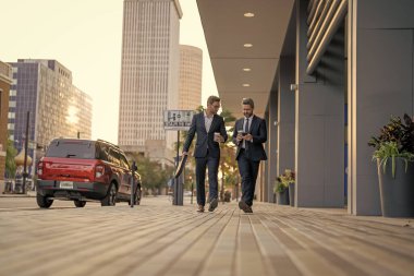 Takım elbiseli işadamları dışarıda yürüyor. Şehirde yürüyen ve konuşan iki işadamı. İş adamları konuşuyor. Yürüyen ve konuşan iki iş adamı. New York 'ta iş arkadaşı yürüyüşü. Başarı. İş alanı.