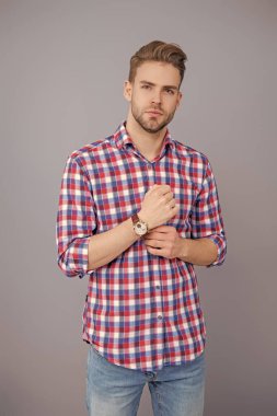 Millennial yakışıklı adam kol saatini gösteriyor. Erkekler için moda aksesuarı. Erkek moda aksesuarı. Eli kollu bir adam. Stüdyoda kol saatini gösteren bir adam. Zaman dakikliği. Lüks kol saati olan adamlar..