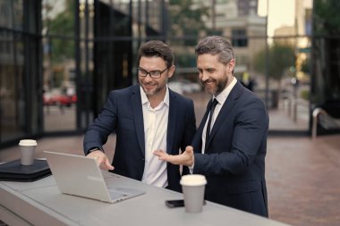 İş adamları açık havada ticaret yapıyor. Araştırma ve finans. İşadamı yatırımcılar dizüstü bilgisayarla borsa ticaretini inceliyor. Yatırım planlama. Amerikalı iş adamları. Borsa ticareti.