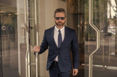 Başarılı bir iş adamı ofise giriyor. Ofis kapısında olgun bir girişimci. Takım elbiseli Amerikalı işadamı ofis binasını terk ediyor. CEO ofise giriyor. İş adamı. Hırslı iş adamı..