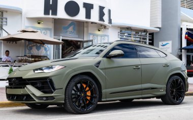 Miami, Florida, ABD - 08 Aralık 2024: Luxur yeşil renkli Lamborghini Urus S tipi spor araba. Lamborghini Urus 'un arabası dışarıda park halinde. Lamborghini Urus, köşe manzaralı. 2024 Lamborghini Urus S SUV arabası.