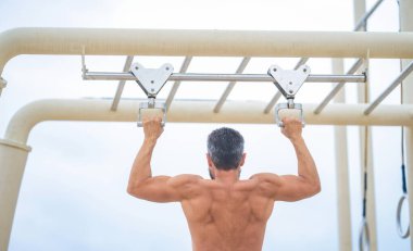 Spor barfiks egzersizi. Spor eğitimi. Sporcu adam egzersiz yapıyor. Adam kaslı sırt sporcusu açık hava spor salonuna geldi. Spor yaşam tarzı. Kas kasları ve trisepsler. Güçlü bir atlet. Adam yanaşıyor..