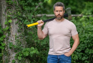 Baltalı İspanyol oduncu adam. Oduncu baltası. Ağaç kesen baltalı adam. Erkeksi vahşi adam. Oduncu dışarıda kamp yapıyor. Acımasız oduncu. Vahşilik ve erkeklik, kopyalama alanı.