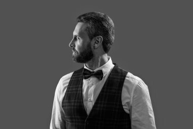 Resmi erkek giyim sektöründe karizmatik bir adam. Yakışıklı garson adam smokin giyer. Şık smokin papyonu. Papyonlu garson servis yapmaya hazır. Garson. Smokinli erkek giysili adam Griler 'de izole edilmiş. Klasik Bowtie..
